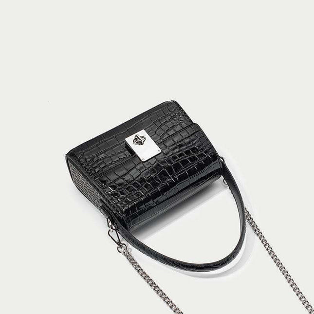 New leather handbag in trapezoid shape with chain strap and crocodile pattern.