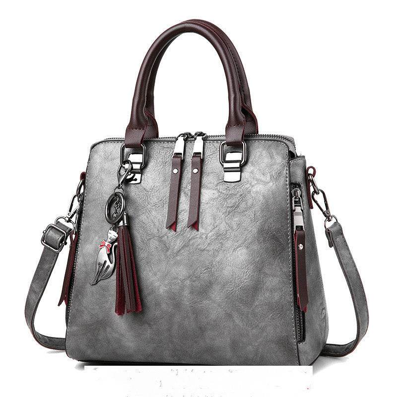 Luxury ladies handbag with soft surface, zipper opening, and adjustable shoulder strap.