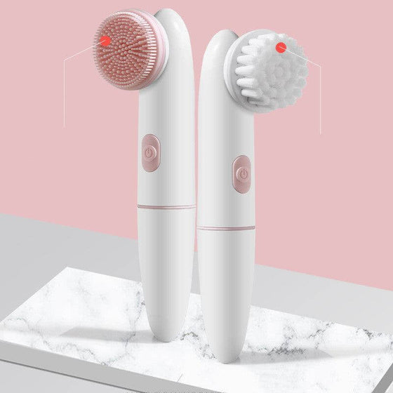 Electric silicone facial cleanser and cleansing brush with silicone bristles on marble surface.