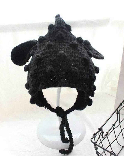 Hand knitted black baby cartoon hat with woven balls and ear flaps.