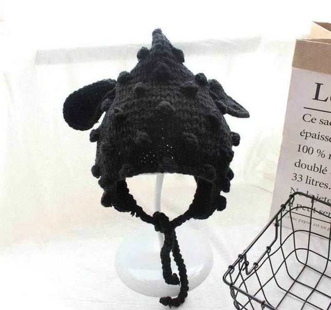 Hand knitted black baby cartoon hat with woven balls and ear flaps.