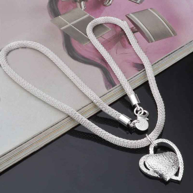 Fine Jewelry Silver Net Style Heart Necklace on a dark background.