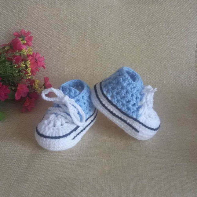 Hand-knitted baby bootees in blue and white, soft and cozy for baby feet.