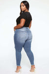 Plus size woman wearing stretch ripped jeans with high waist.