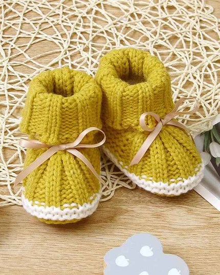 Fashionable and lightweight yellow toddler shoes with pink laces on woven mat.