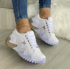 Women's lace-up sports sneakers with patent leather and sponge cake heel in white.