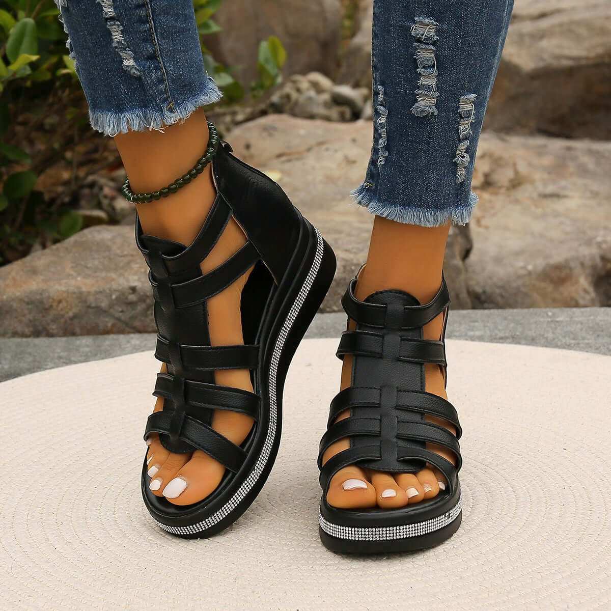 Cutout Rhinestone Trim Wedge Sandals with black straps and wedge heel worn with distressed jeans.