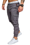 Men's grey woven fabric casual pants with cargo pockets, styled with a Calvin Klein waistband and white sneakers.