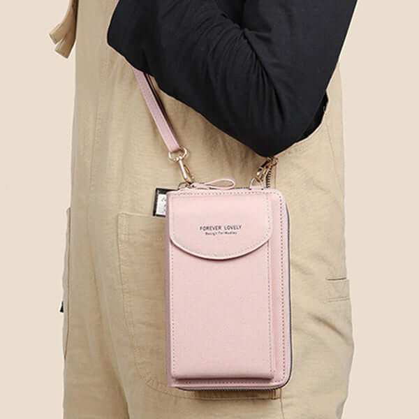 Women mobile phone crossbody large wallet shoulder bag in pink PU leather shown in use.