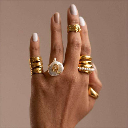 Cosmic Constellation Ring on hand with other gold jewelry.