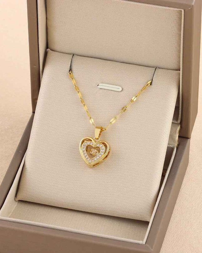 Gold chain necklace with heart-shaped pendant in a jewelry box from Plush Fashions Shop.