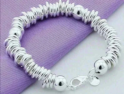 Elegant 925 silver color charm cuff bangle for women on purple fabric.