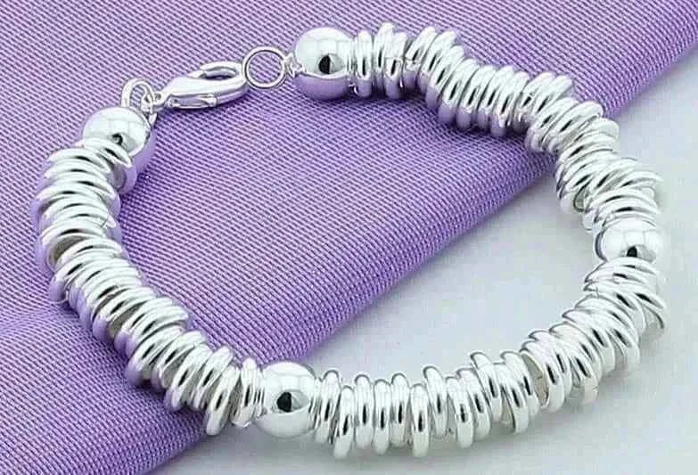 Elegant 925 silver charm cuff bangle for women on purple cloth.