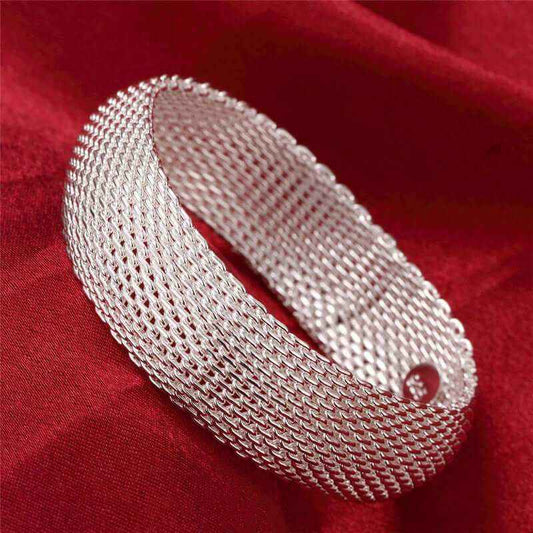 Women's silver mesh bracelet with unique design on red background.