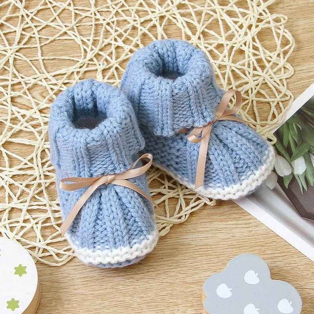 Fashionable and lightweight blue toddler shoes with ribbon detail on a woven background.