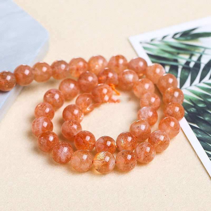 Natural gold sunstone beaded bracelet for DIY jewelry accessories on beige surface.