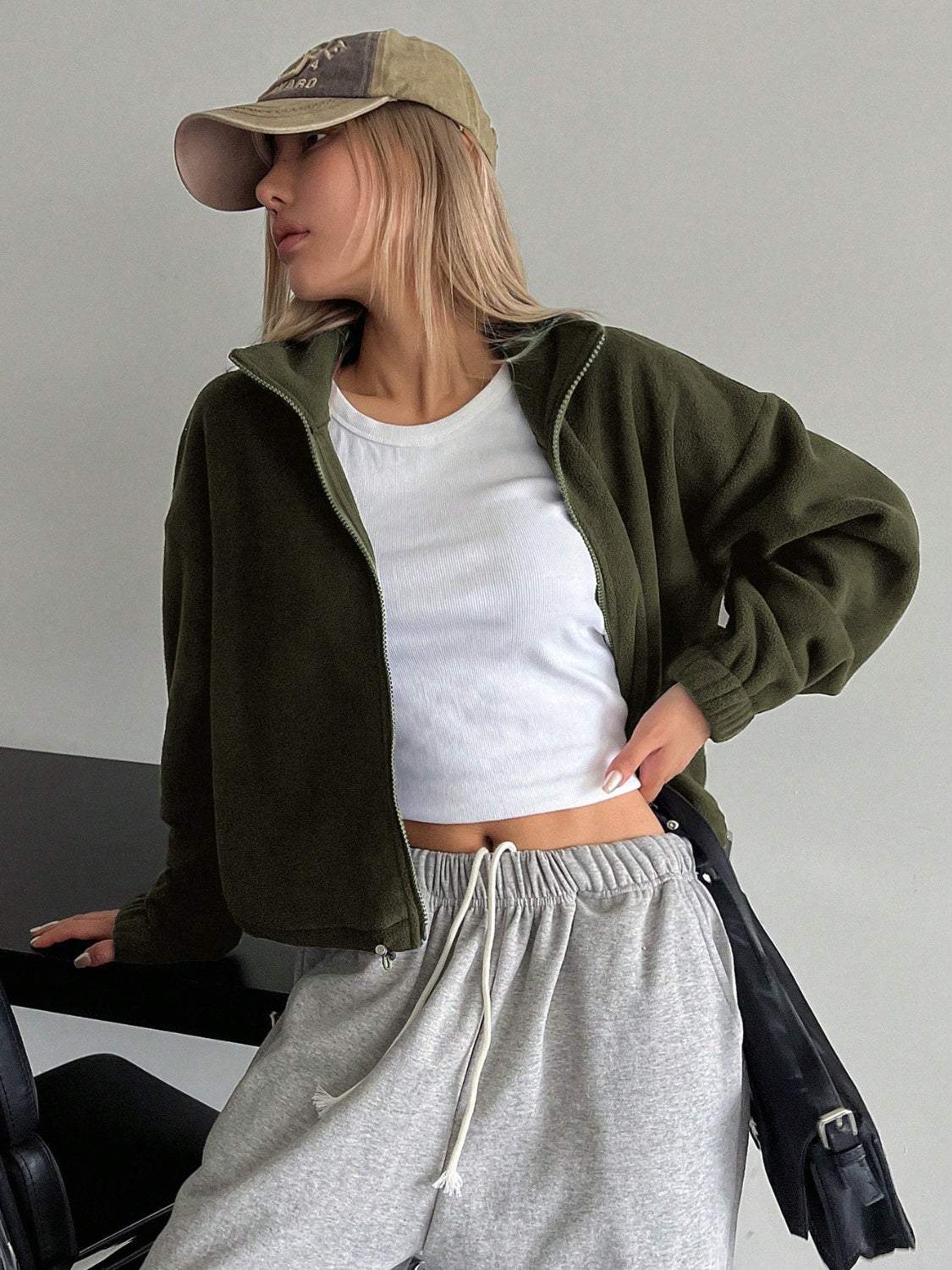 Honey Zip Up Long Sleeve Cropped Jacket in olive, unlined polyester material, styled with casual attire.