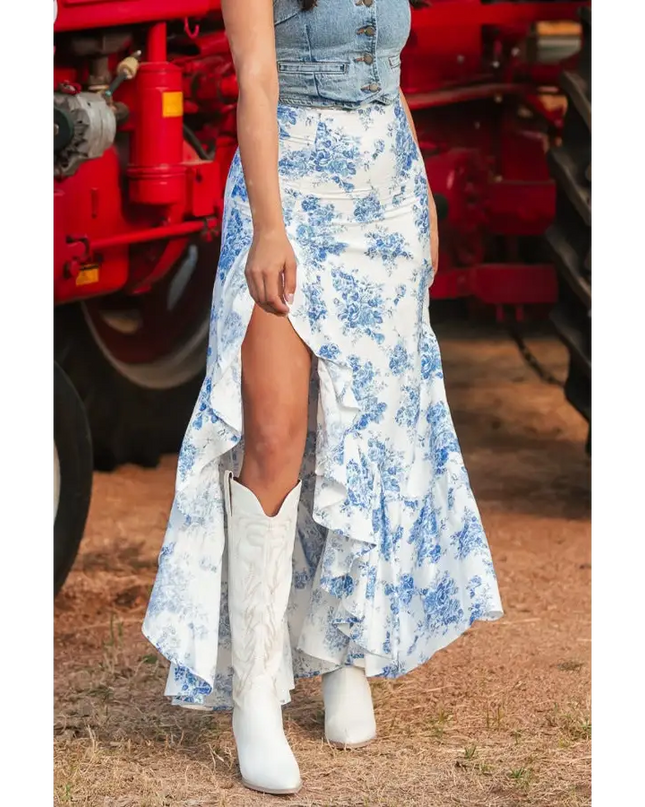 Woman in split asymmetrical ruffled printed skirt and white cowboy boots